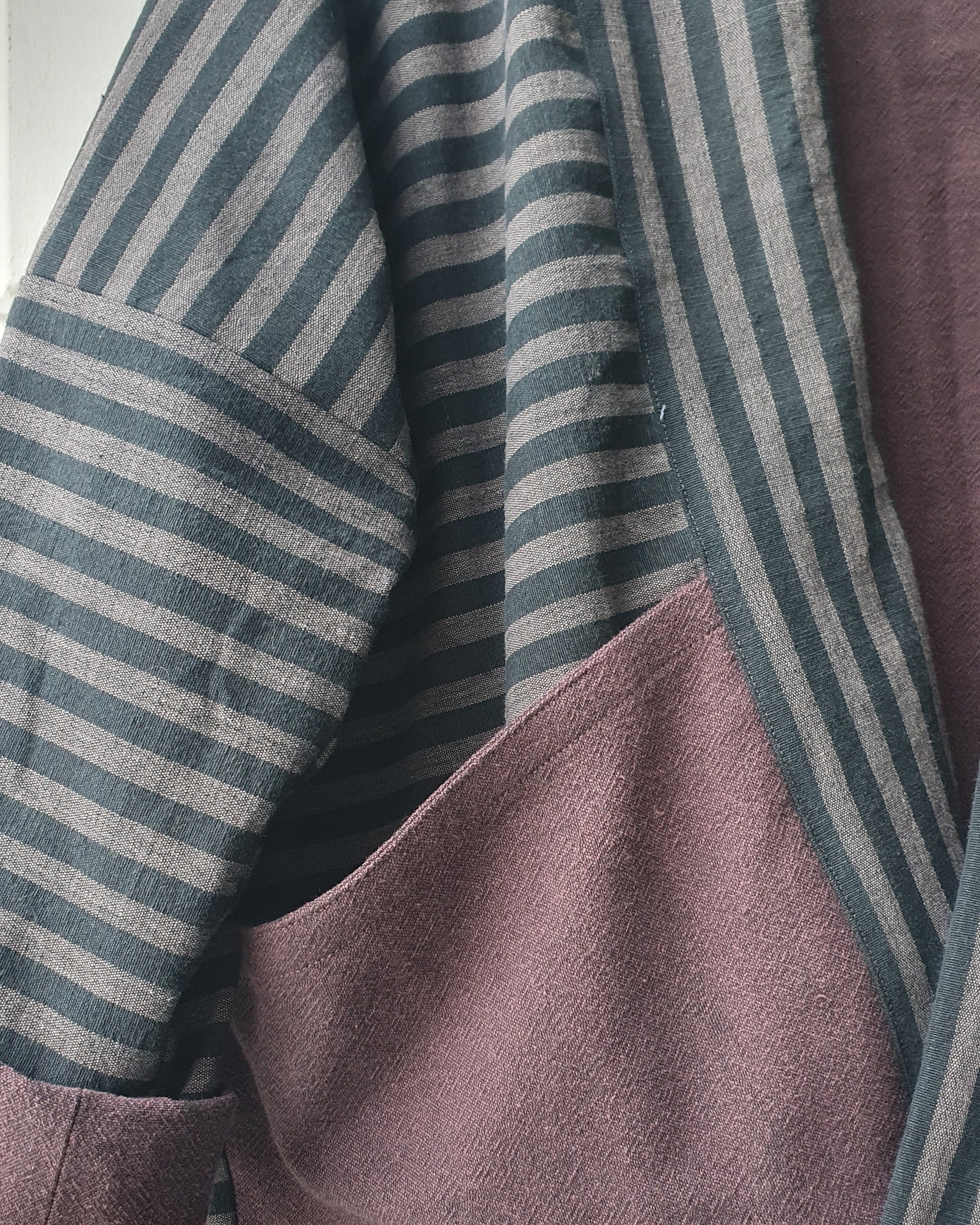 Striped Haori kimono jacket with cotton lining in black and grey stripes and aubergine colors. This jacket has large pockets on the front. Made by Atelier Heimat, handcrafted by Kachiri Faes.