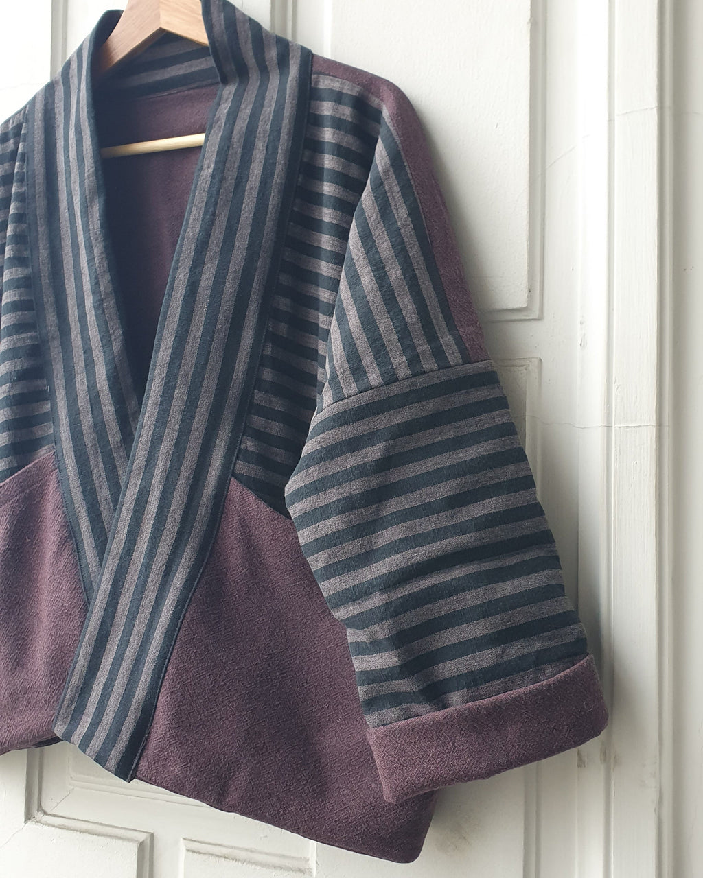 Striped Haori kimono jacket with cotton lining in black and grey stripes and aubergine colors. This jacket has large pockets on the front. Made by Atelier Heimat, handcrafted by Kachiri Faes.