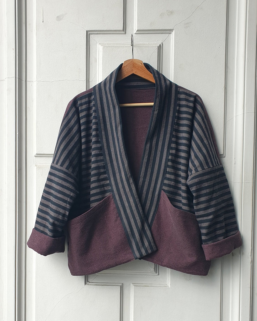 Striped Haori kimono jacket with cotton lining in black and grey stripes and aubergine colors. This jacket has large pockets on the front. Made by Atelier Heimat, handcrafted by Kachiri Faes.