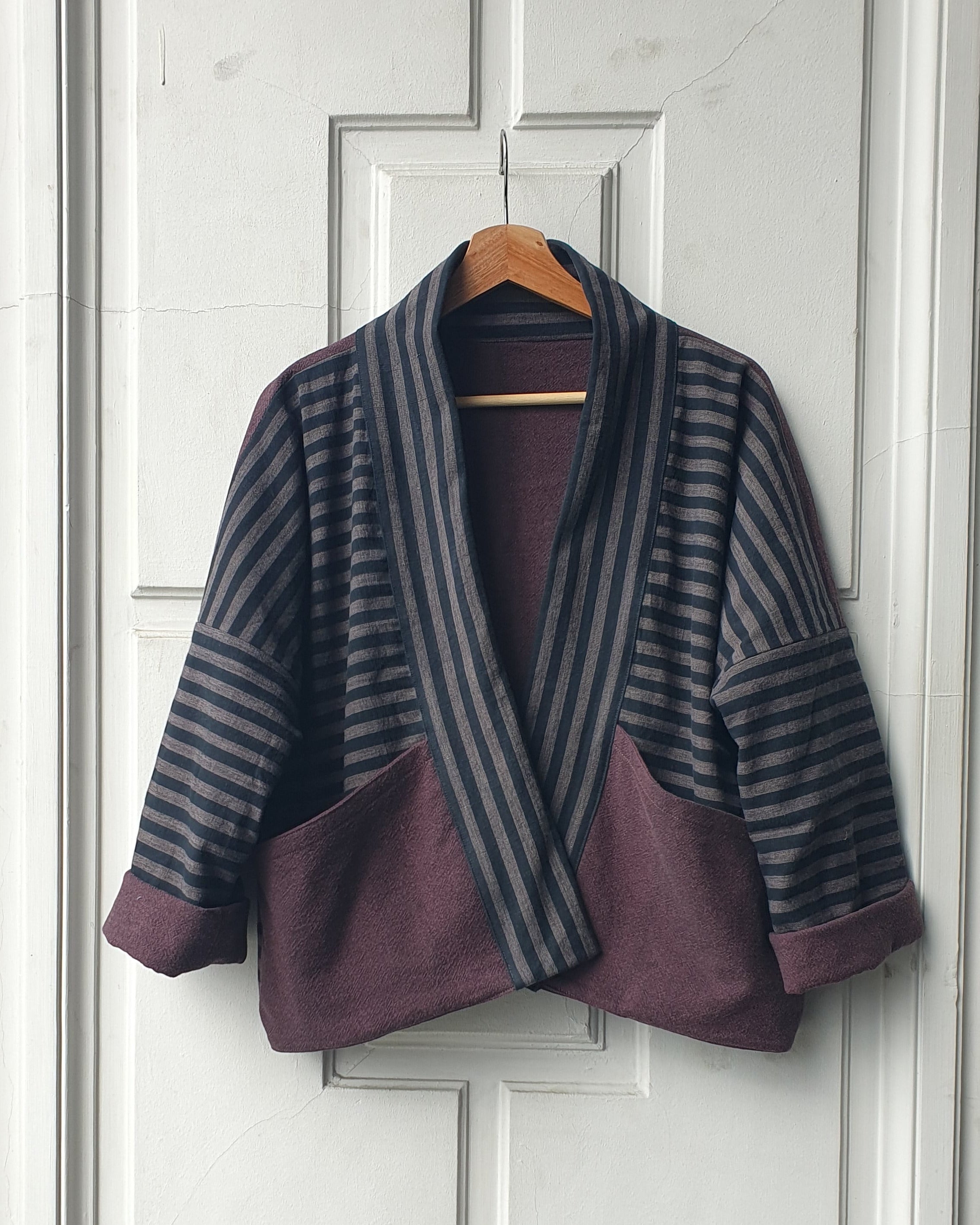 Striped Haori kimono jacket with cotton lining in black and grey stripes and aubergine colors. This jacket has large pockets on the front. Made by Atelier Heimat, handcrafted by Kachiri Faes.